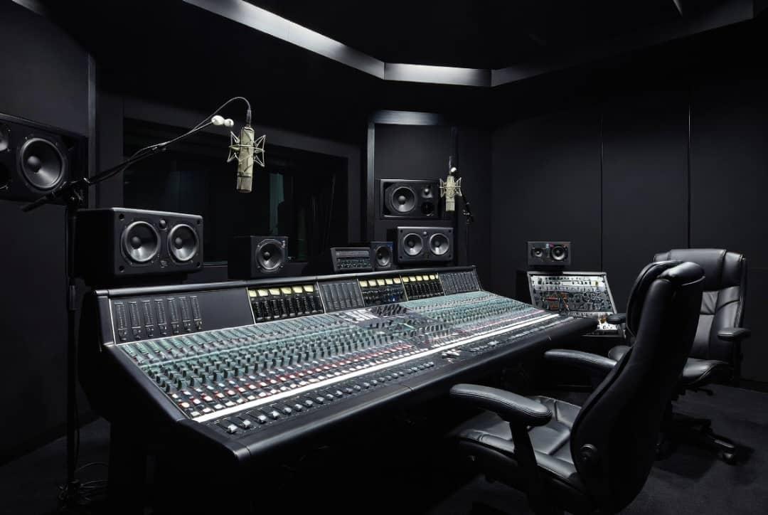 A professional recording studio console in low light