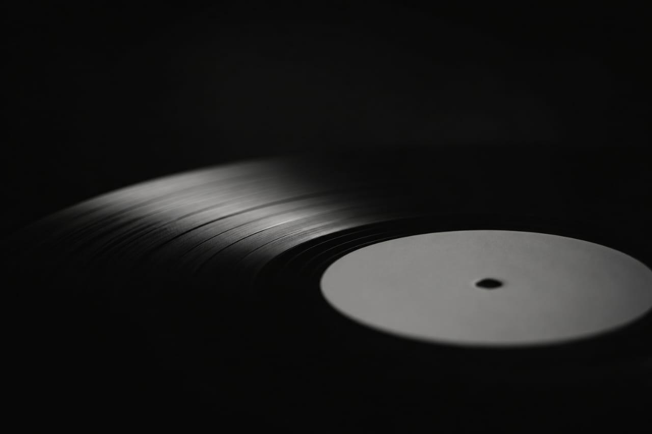 A vinyl record catching a single shaft of light